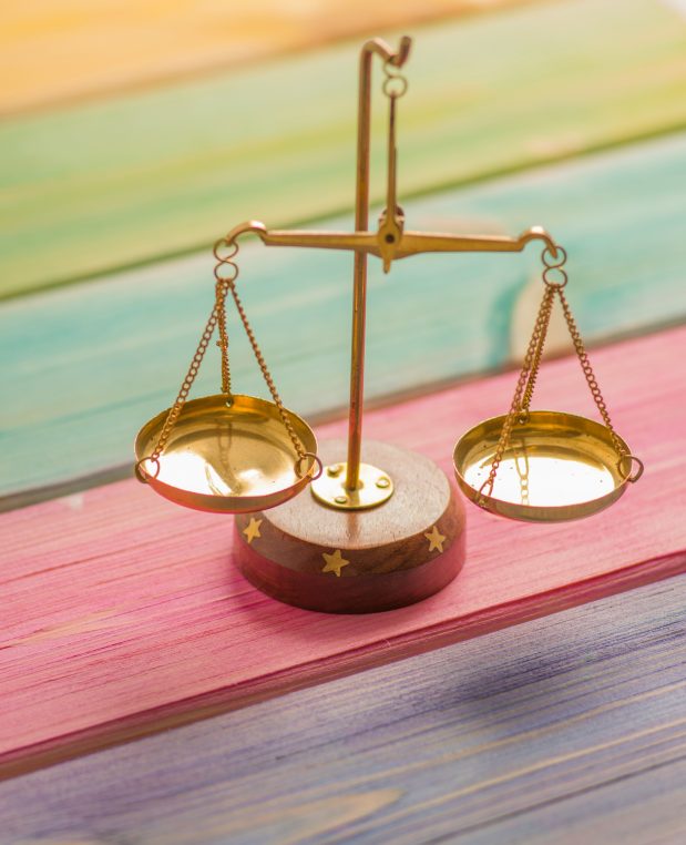 a small brass old style scale on a colorful wood table