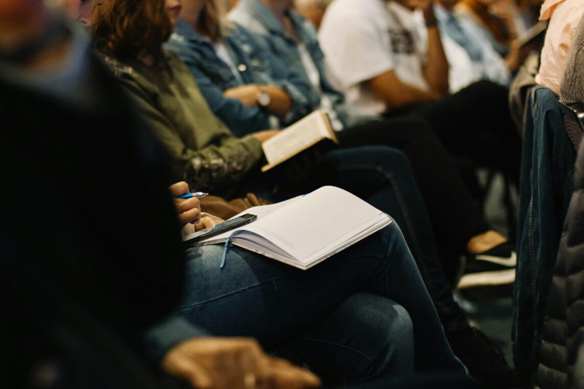 A group learning situation with people having open notebooks on their laps